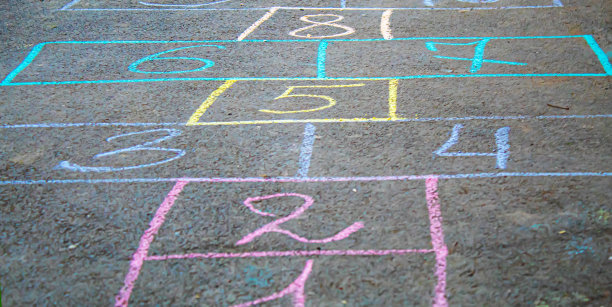 孩子们在人行道上跳经典。有选择性的重点。图片下载