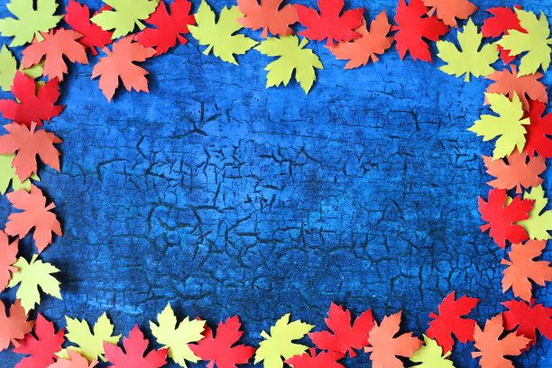 图片的秋天设计海报框架，自制剪影剪纸形状的秋天彩色树叶，边界的红色，橙色和黄色的枫叶形状的裂纹蓝色背景，秋天的壁纸背景，复制空间图片下载