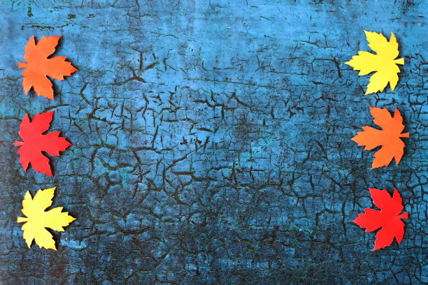 图片的秋天设计海报框架，自制剪影剪纸形状的秋天彩色树叶，边界的红色，橙色和黄色的枫叶形状的裂纹蓝色背景，秋天的壁纸背景，复制空间图片下载