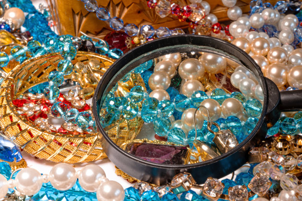 以放大镜为背景的五彩闪亮珠宝，寓意繁荣，特写图片下载
