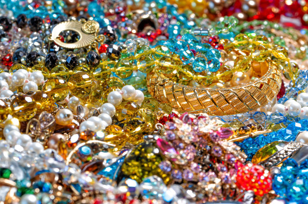 项链、耳环、手链、珍珠、珠子和各种颜色的宝石作为背景图片下载