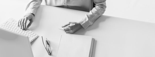 裁剪的顶视图，年轻的商业妇女在办公室工作，做笔记。黑白效果图片下载