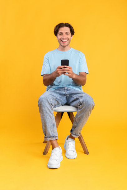 在演播室用手机的快乐家伙图片下载