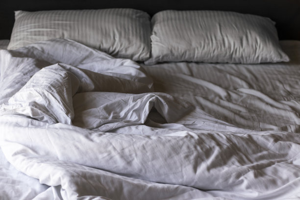 早上有白色皱褶床单的空床图片下载