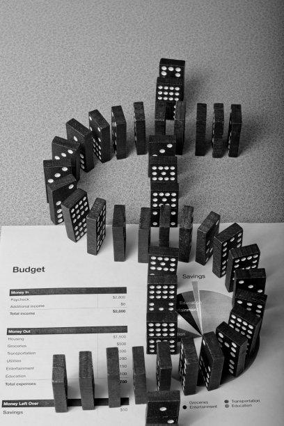 在个人预算汇总表上形成一个美元符号的多米诺骨牌。图片下载