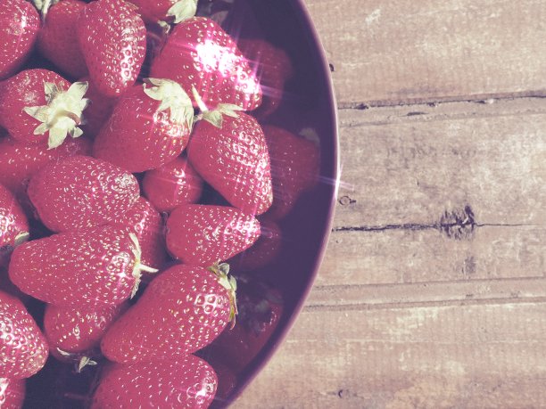 草莓放在盘子里，木制背景。深色的陶瓷盘子和美味的红色大草莓。健康的食物，维生素和素食有食物的静物。副本的空间。平的。图片下载