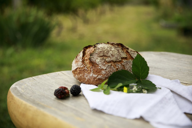 一个自制的生面团，乡村面包烘烤，放在木桌上。水平的观点。图片下载