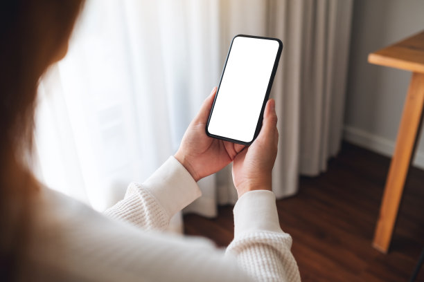一个女人拿着手机，家里的桌面是白屏图片下载