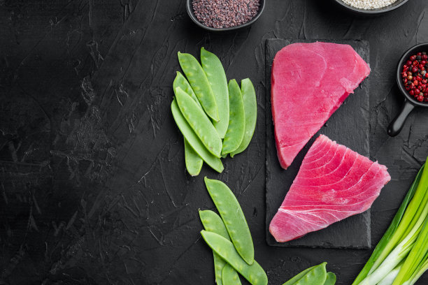 生芝麻金枪鱼牛排的原料，在石板上，在黑色的石头背景上，俯视图平躺，有复制空间和文本空间图片下载
