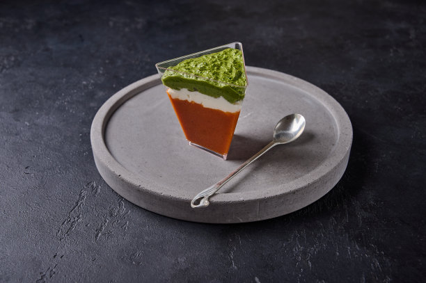 在灰色的陶瓷盘上用勺子盛上烤胡椒和奶油干酪和香蒜酱图片下载