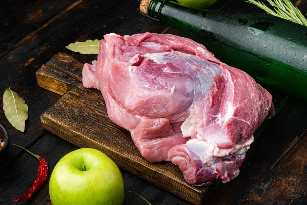 生猪排加油和香料，用于烧烤或烹饪，配苹果干苹果酒，放在旧的深色木桌背景上图片下载