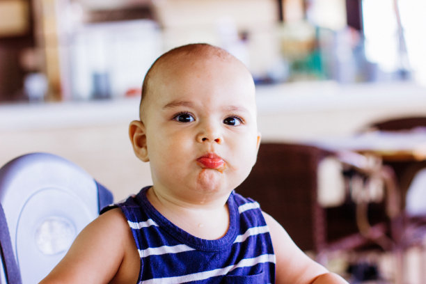 可爱的小男孩坐在餐厅的高脚椅上。带孩子去酒店度假图片下载