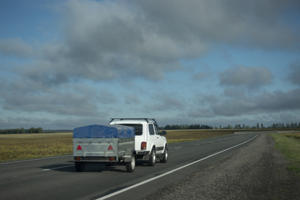 一辆拖着拖车的汽车在路上行驶图片下载