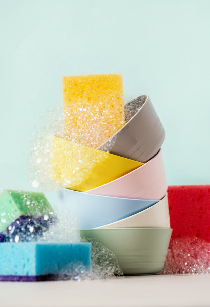 蓝色背景上用于洗碗的各种碗和海绵图片下载