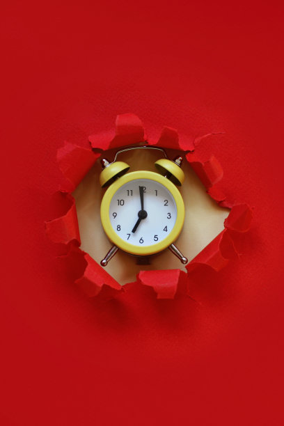 黄色闹钟从纸洞里出来图片下载