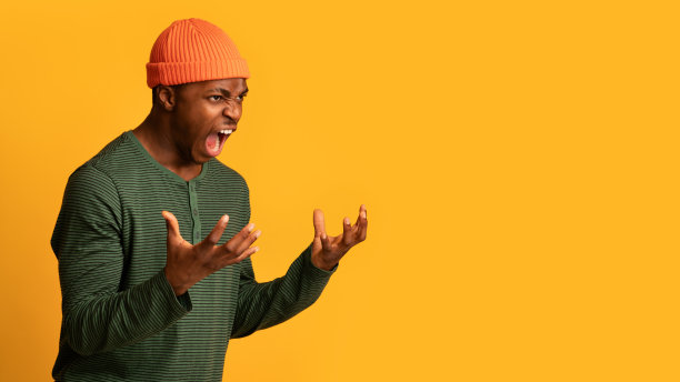 愤怒的非洲裔美国人的肖像在黄色背景下愤怒地尖叫图片下载