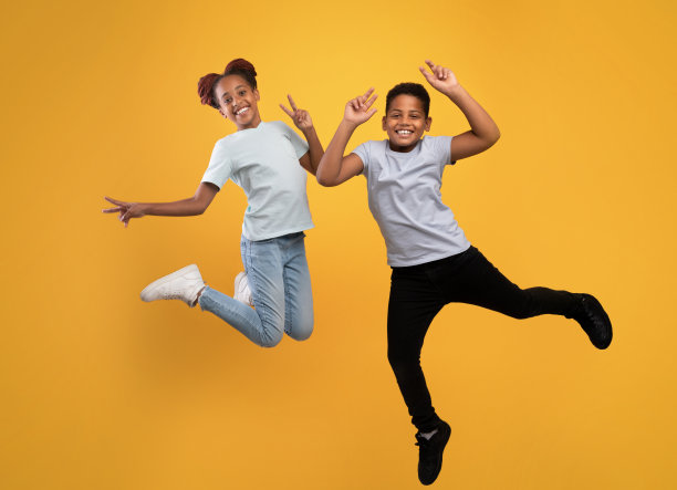 快乐的非洲裔美国兄妹在黄色上嬉戏图片下载