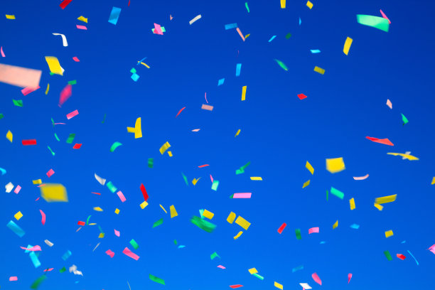五彩缤纷的五彩纸屑在清澈的蓝天背景上。h的概念图片下载