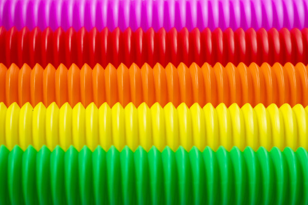 五颜六色的抗压力烦躁推流行管感官玩具的孩子在蓝色的背景。俯视图，平躺。创意游戏的特写与流行的塑料柔性亮波纹管。图片下载