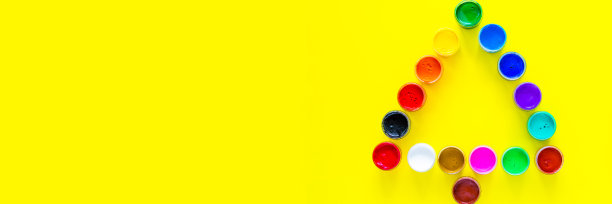 在黄色背景上用颜料罐做成的创意圣诞树图片下载