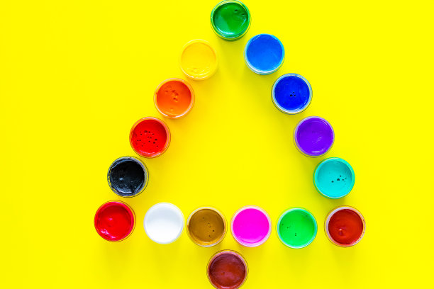 在黄色背景上用颜料罐做成的创意圣诞树。俯视图，平铺，复制空间，隔离图片下载