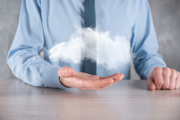 商人手捧云。云计算的概念，年轻的商人与云在他的手。云服务的概念。图片下载