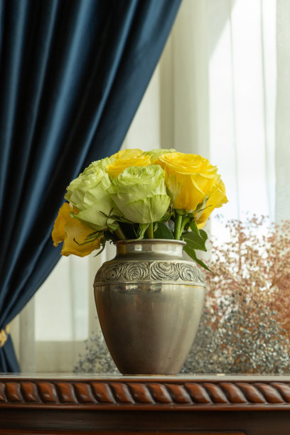 由一个金属花瓶装饰一束黄白玫瑰，装饰元素与自然，背景幕布图片下载