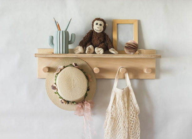 儿童房的木架墙上挂着玩具，一顶儿童草帽，一个书包。室内概念图片下载