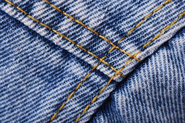 旧的蓝色牛仔裤背景和纹理接近。牛仔布缝。图片下载