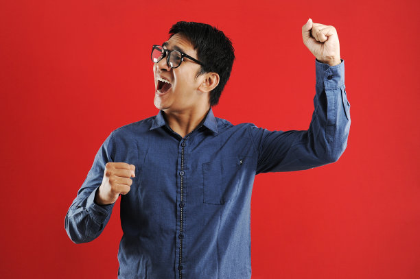 年轻的亚洲人高兴和兴奋的表达胜利的姿态。成功和庆祝图片下载