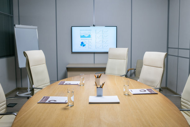 大桌子周围有扶手椅，桌上放着纸、眼镜和笔图片下载