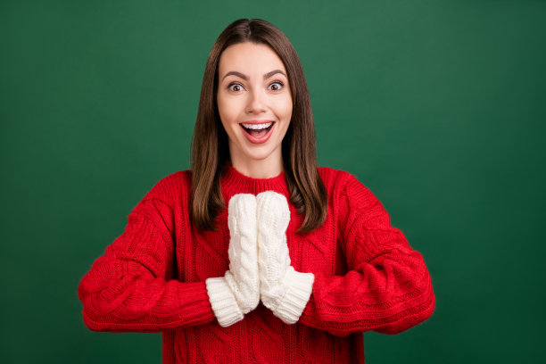 照片年轻兴奋的女孩快乐积极的微笑惊讶的惊讶戴手套冬季隔离在绿色的背景图片下载