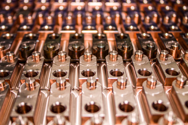 开槽的金属板被分开排列成大量的穿孔块，整齐地堆叠在彼此的顶部。图片下载