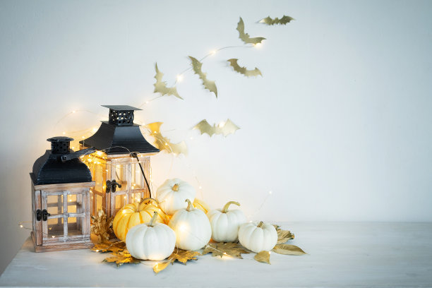 万圣节桌上的装饰品:迷你南瓜，复古的灯笼，花环，金色的叶子和蝙蝠。图片下载