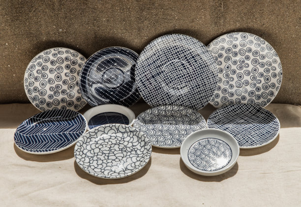 一套蓝色瓷杯在白布织物布。陶瓷餐具。图片下载