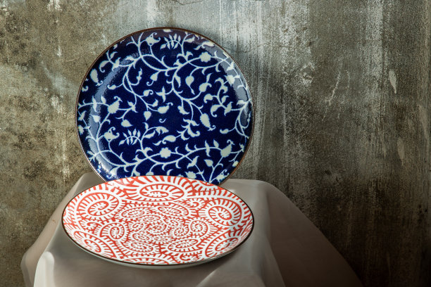 两个陶瓷盘子放在粉红色的桌布上。图片下载