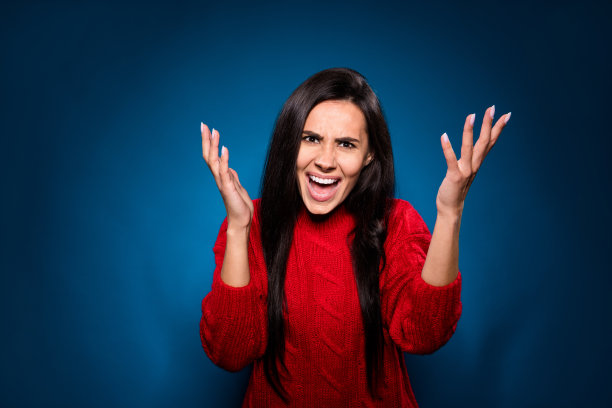 愤怒的年轻女士穿着针织毛衣尖叫着举起双臂孤立的渐变蓝色背景照片图片下载