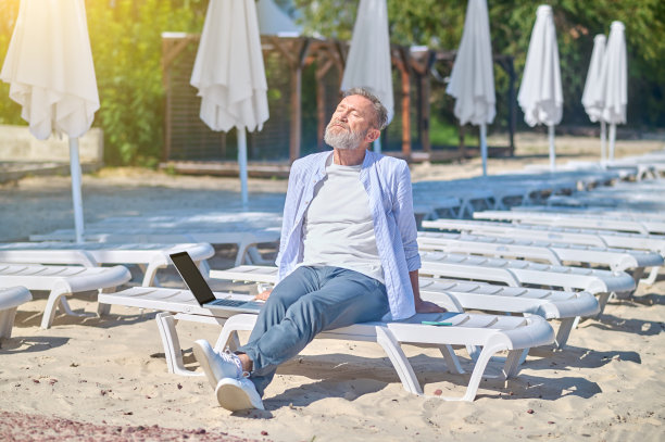 一个男人坐在躺椅上晒太阳图片下载