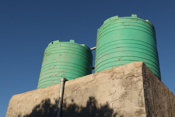 从屋顶收集水的塑料住宅水箱。图片下载