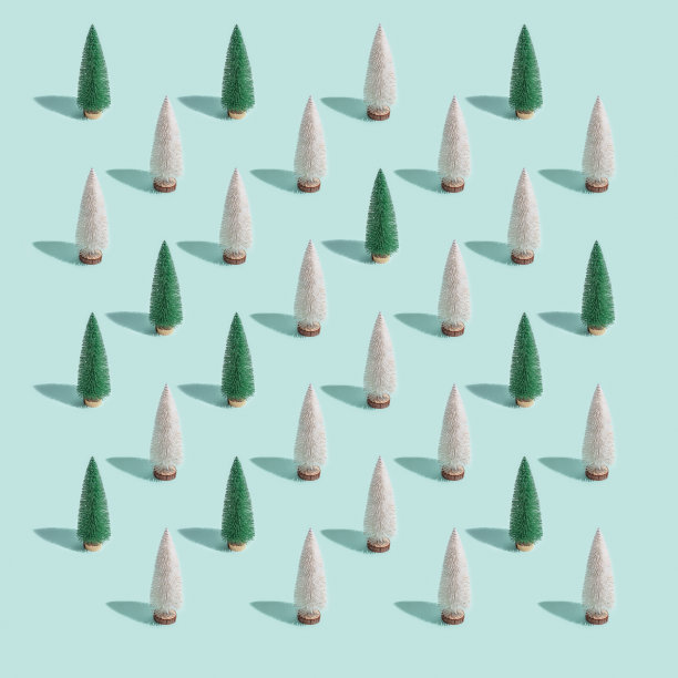 闪亮的圣诞树图案，明亮的白色和绿色冷杉在柔和的蓝色背景。冬天的节日快乐。新年最低卡。图片下载