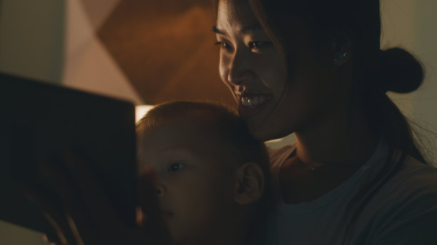 母亲和儿子在晚上看视频图片下载
