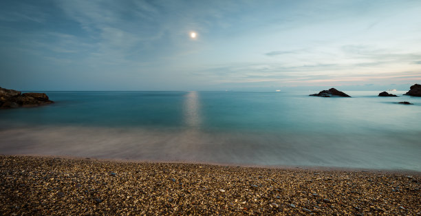 晚上海面。电影过滤器。地中海沿岸。沙滩上的卵石。在意大利利古利亚。长时间的曝光。图片下载