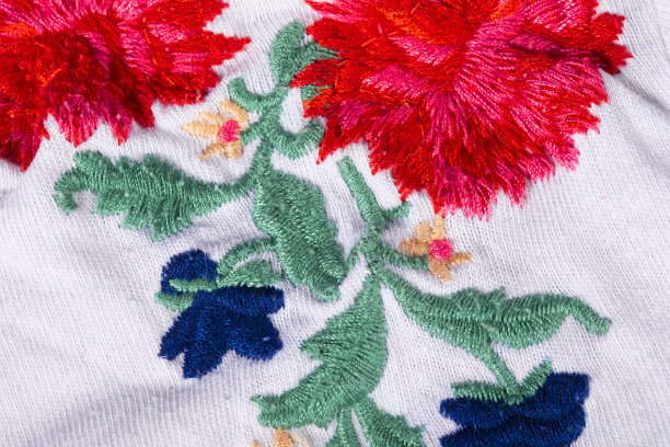 一块绣有鲜艳花朵的白色棉布。图片下载