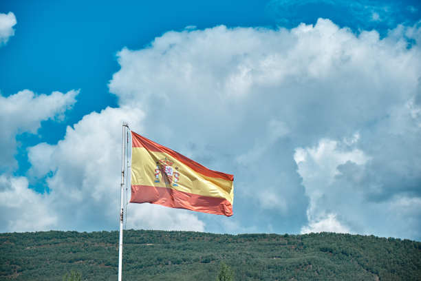蓝天白云之上的西班牙国旗-西班牙宪法旗图片下载