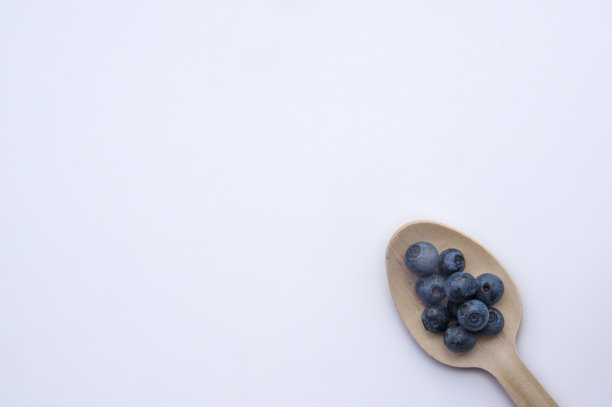 独立回收的勺子和多汁的新鲜蓝莓放在白色的桌子上图片下载