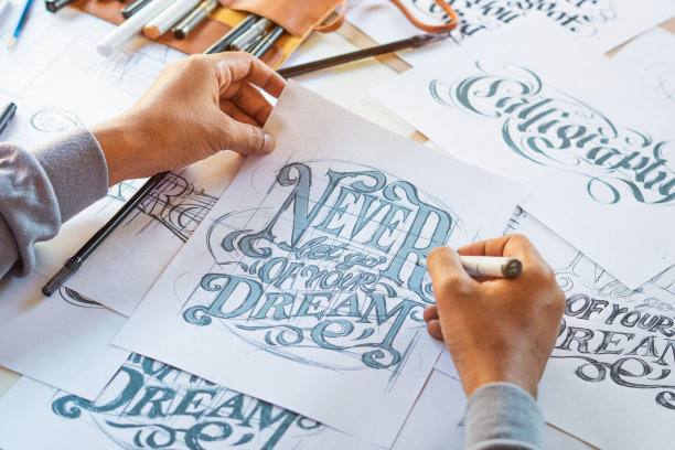 字体印刷书法艺术家设计师画草图写让拼写钢笔毛笔墨水纸桌子艺术品。工作场所的设计工作室。图片下载