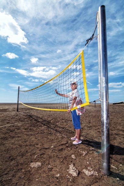 孤独的老女人忧郁地看着沙滩排球网图片下载