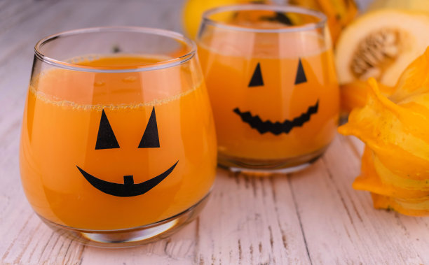 南瓜汁，装饰有女巫帽的眼镜为孩子们的派对和万圣节的款待。图片下载