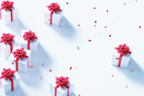 红色的五彩纸屑落在白色的礼品盒上，白色的背景图片下载