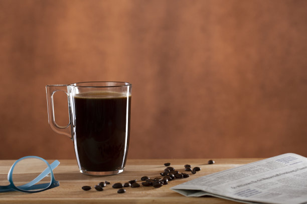 早晨的黑咖啡杯，报纸和老花镜图片下载